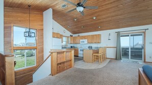 Una cocina amplia con armarios de madera, una isla central y un ventilador de techo.