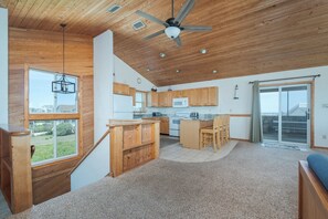 A spacious kitchen with wooden cabinets, a central island, and a ceiling fan.