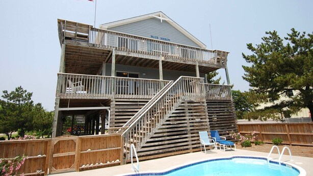Un edificio de dos pisos con un balcón y una bandera.