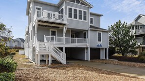 Une maison à deux étages avec un balcon, un garage et une allée.