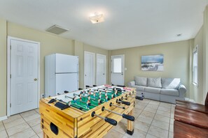 Relax in a cozy living space with a foosball table, sofa, and coffee table.