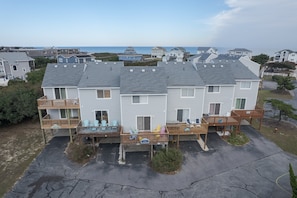 A two-story building with a balcony and a deck, featuring a view of the ocean.