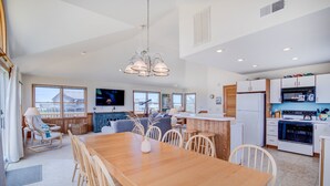 A modern kitchen with a dining area, wooden furniture, and large windows. - 2850 - SunDancer, Pet-Friendly Duck Retreat Near Beach & Town (Duck)