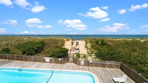 A wooden deck with a pool, leading to a beach with a sandy path and a wooden fence. - 5619- Pura Vida, Oceanfront fully equiped condo! (Nags Head)