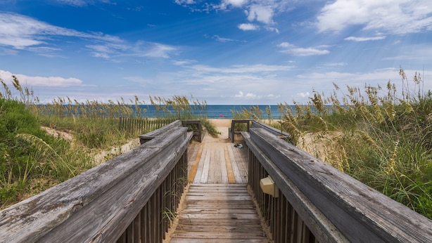 A wooden boardwalk leading to a beach with sand and grass on either side. - 5619- Pura Vida, Oceanfront fully equiped condo! (Nags Head)