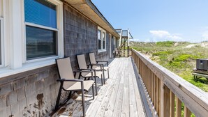 A wooden deck with chairs, a wooden railing, and a view of the beach. - 7847- Summerset - Dog Friendly Oceanfront Retreat in Frisco (Frisco)