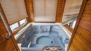 Una cabaña de madera con jacuzzi.