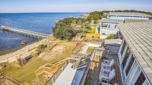 Una propiedad costera con una terraza de madera, piscina y vista al mar.