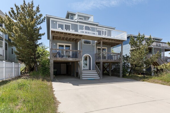 A two-story house with a balcony, a covered porch, and a front entrance. - 1886 - Got Beach - Corolla Semi-Oceanfront | Pool & Hot Tub (Corolla)