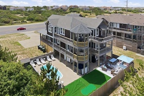 A multi-story building with a pool, outdoor seating, and a view of the surrounding area.