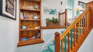 Eine Treppe mit Holzgeländern und einem grünen Teppich.