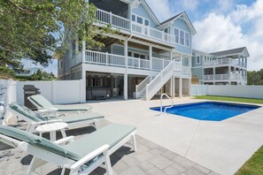 A two-story house with a pool, outdoor furniture, and a staircase leading to the upper level. - 4918- Stress Less - Kitty Hawk Escape w/ Pool & Hot Tub (Kitty Hawk)