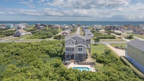 A coastal residential area with houses, a swimming pool, and a view of the ocean. - 5788- Birds Eye View - Beach Getaway in Nags Head | Private Pool (Nags Head)