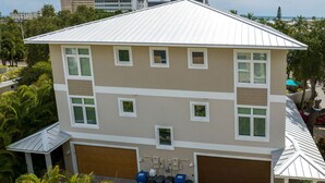 A multi-story building with a flat roof, multiple windows, and a garage. - NO Bunks-King beds, Garage Parking, Private Beach Access-Less Crowded (Siesta Key)