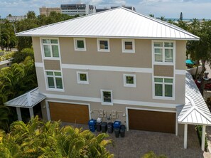 A multi-story building with a flat roof, multiple windows, and a garage.