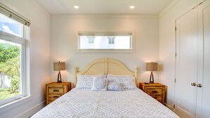 A bedroom with a bed, two bedside tables with lamps, a window, and a door. - NO Bunks-King beds, Garage Parking, Private Beach Access-Less Crowded (Siesta Key)