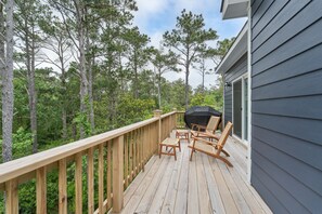 Relax on the deck overlooking the dense forest, where you can dine or unwind in the wicker chairs.