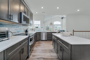 Enjoy cooking in this well-lit kitchen with a large island and sink.