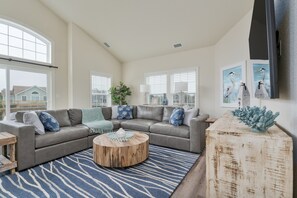 Relax in this stylish living room with a large L-shaped sofa, wooden coffee table, and vaulted ceiling.