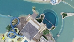 Vista aérea de un parque acuático con múltiples toboganes, una piscina y zonas de descanso.