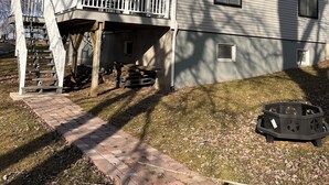 A single-story house with a covered porch and a staircase leading to a deck. - Newly remodeled Riverfront 3 bedroom house on the Great Chazy River with dockage (Champlain)