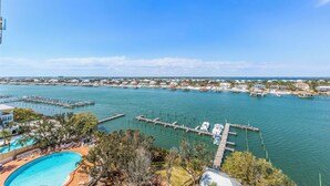 Un puerto deportivo con barcos amarrados, una piscina y vistas de la zona residencial circundante.