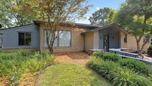 A two-story house with a front yard, a small porch, and a garage. - Rockford Retro Revival • Indoor Pool + Arcade Fun! (Rockford)