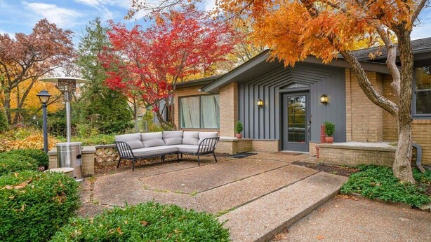A modern house with a covered patio, a gray exterior, and a front door with a small porch. - Rockford Retro Revival • Indoor Pool + Arcade Fun! (Rockford)