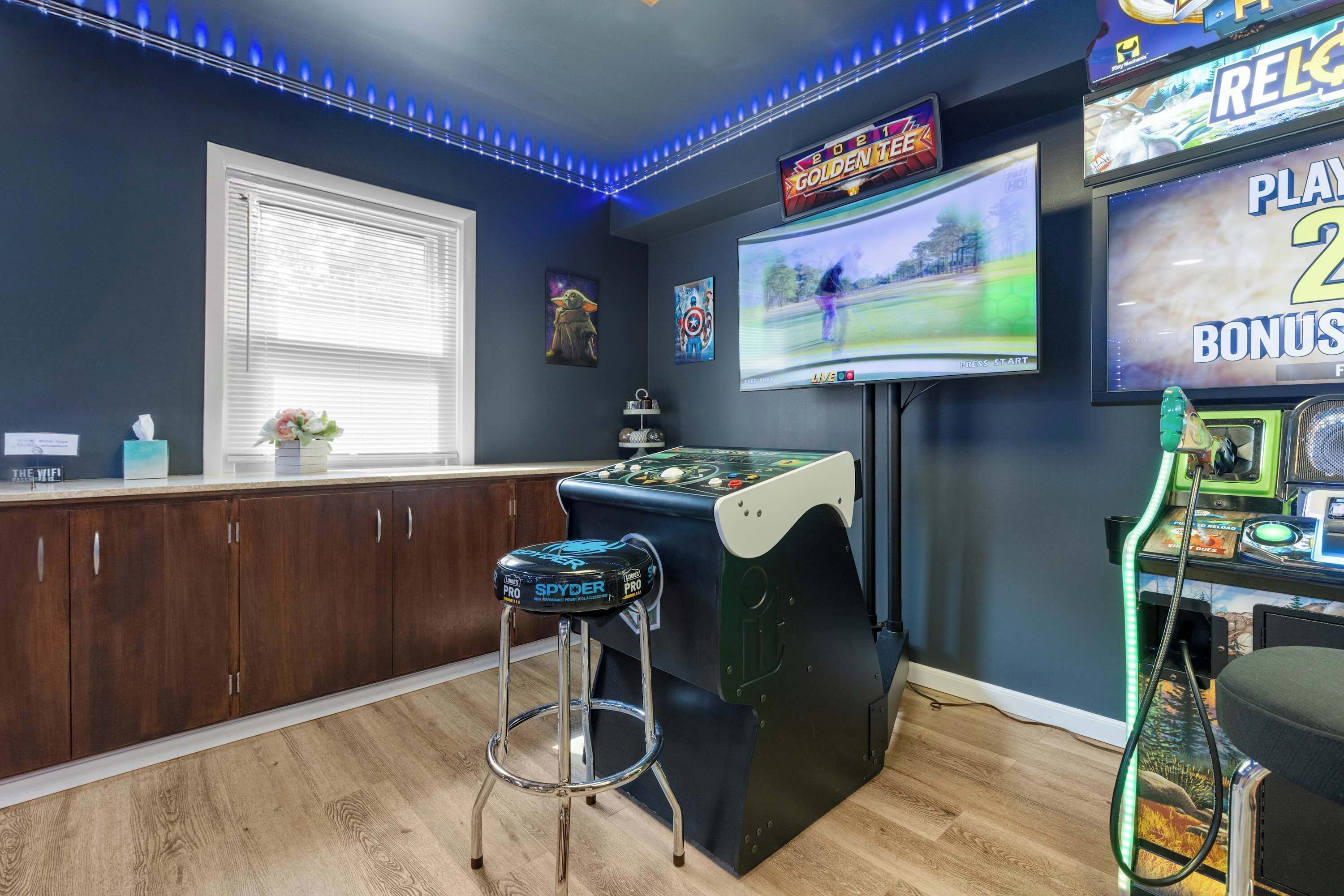 Un espace bar avec une table de billard, des tabourets et des jeux d’arcade.