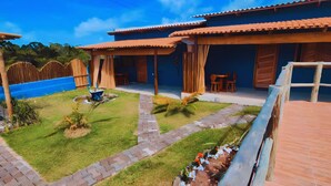 Una casa con patio, piscina e giardino.