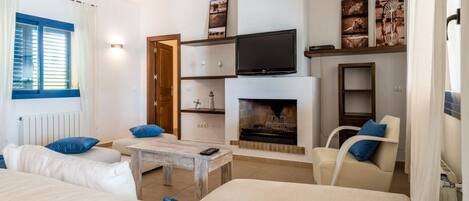 A modern living room with a fireplace, a television, and a sofa.