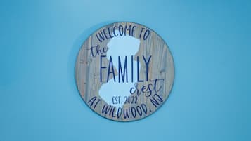 A circular wooden sign with the text "WELCOME TO the FAMILY" and "EST. 2022 AT WILDWOOD, NJ".