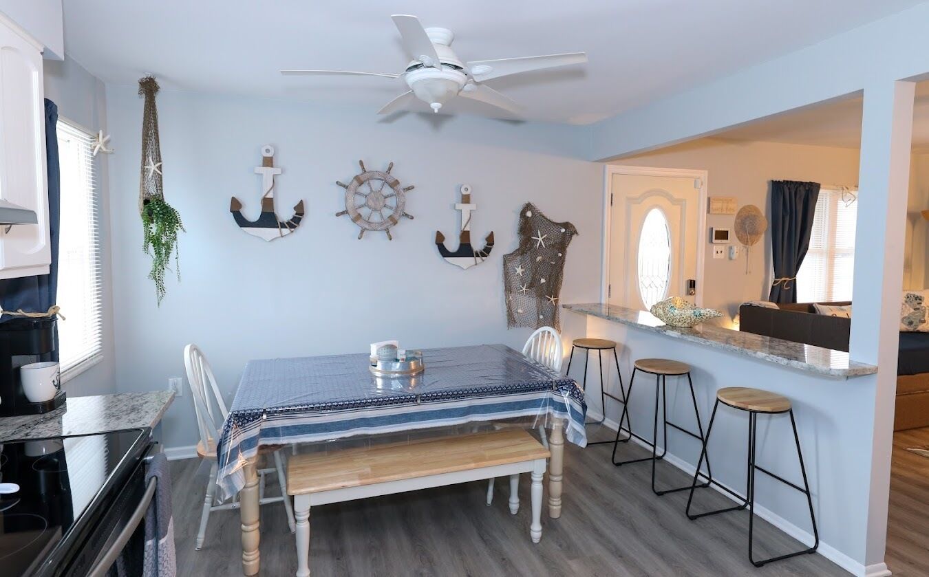 A dining area with a table, chairs, and a bar counter with stools.