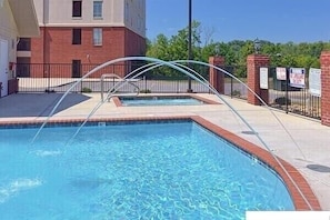 Relax by the rectangular pool surrounded by a tiled deck and a metal archway entrance.