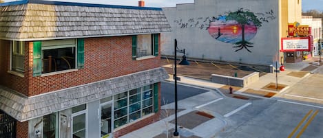 A two-story building with a brick facade and a large mural on the side.