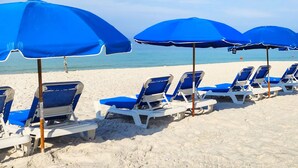 A beach with rows of blue beach chairs and umbrellas. - Beachfront Condo w/ FREE Beach Service, 2nd Floor, Pools, Saunas, Tootsie's (Panama City Beach)