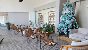 A spacious lobby with a patterned floor, wicker furniture, and a large Christmas tree. - Lovely condo with beach, mountain and pool view. (Nueva Gorgona)