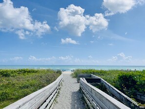 A wooden boardwalk leading to a beach with clear skies and calm waters. - Jupiter Island Beaches, Waterfront Home, Ocean Access, Pool & Boat Dock. (Hobe Sound)