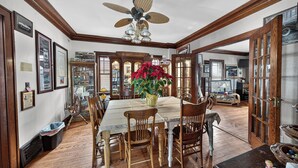 A dining room with a wooden table, chairs, a ceiling fan, and a potted plant. - The Avanti Houses (South Bend)