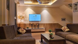 A modern living room with two sofas, a coffee table, and a TV mounted on the wall.