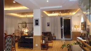A modern living room with wooden flooring, a sofa, a coffee table, and a bookshelf.