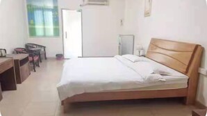 A hotel room with a bed, a desk, a chair, and a window. - kang tai gong yi (Dongguan)