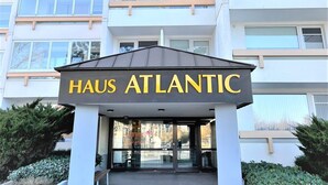 L’entrée de Haus Atlantic se distingue par son design moderne, un panneau bien visible et une allée couverte.