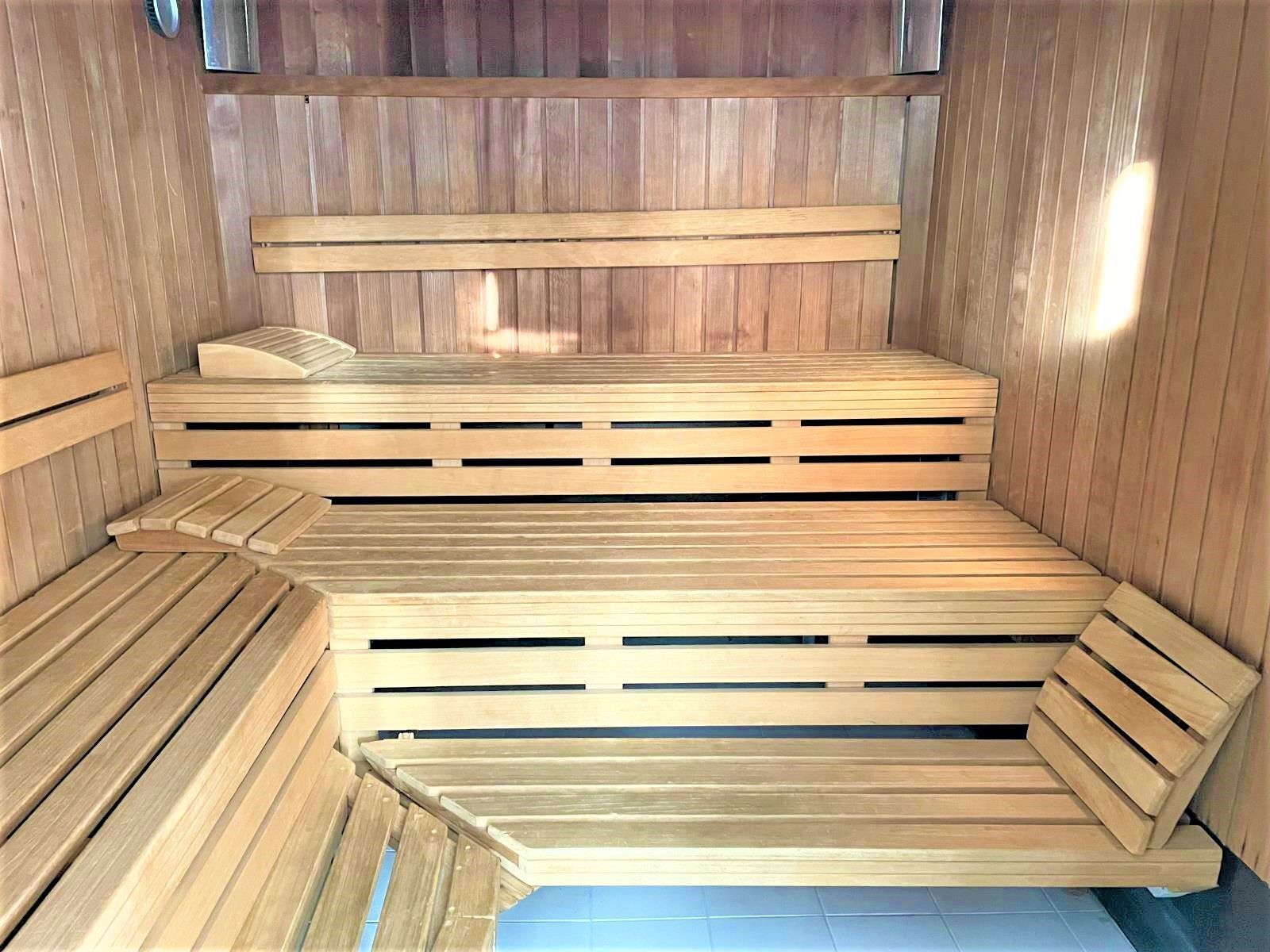 Una sauna con bancos de madera y suelo de baldosas.