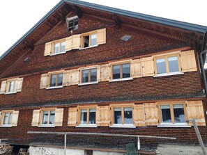 Un edificio in legno a più piani con numerose finestre e un tetto spiovente.