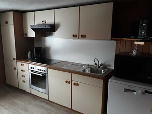 Una cucina con piano cottura, forno, lavello e pensili.