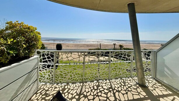 A balcony with a view of the beach, a white decorative fence, and a concrete floor. - Apartment 2-6 pers, 2 bdr, balcony, pool, beach access, parking (La Tranche-sur-Mer)