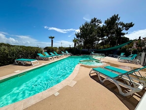 A swimming pool with multiple lounge chairs and a palm tree. - Apartment 2-6 pers, 2 bdr, balcony, pool, beach access, parking (La Tranche-sur-Mer)