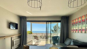 A modern room with a balcony, a dining table, and a sofa. - Seafront Apartment, Direct Beach Access, Balcony, Pool, Jacuzzi, Parking, Sleeps 6 (La Tranche-sur-Mer)