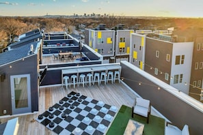 A rooftop terrace with a checkered floor, seating, and string lights. - Tim & Faith's Rooftop - Brand New Nashville Hang Out (Nashville)
